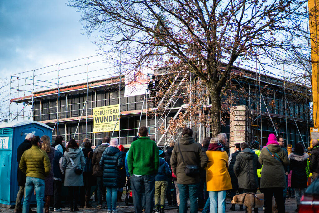 Bauarbeiter bei der Montage einer Holzfassade am Technologie Campus